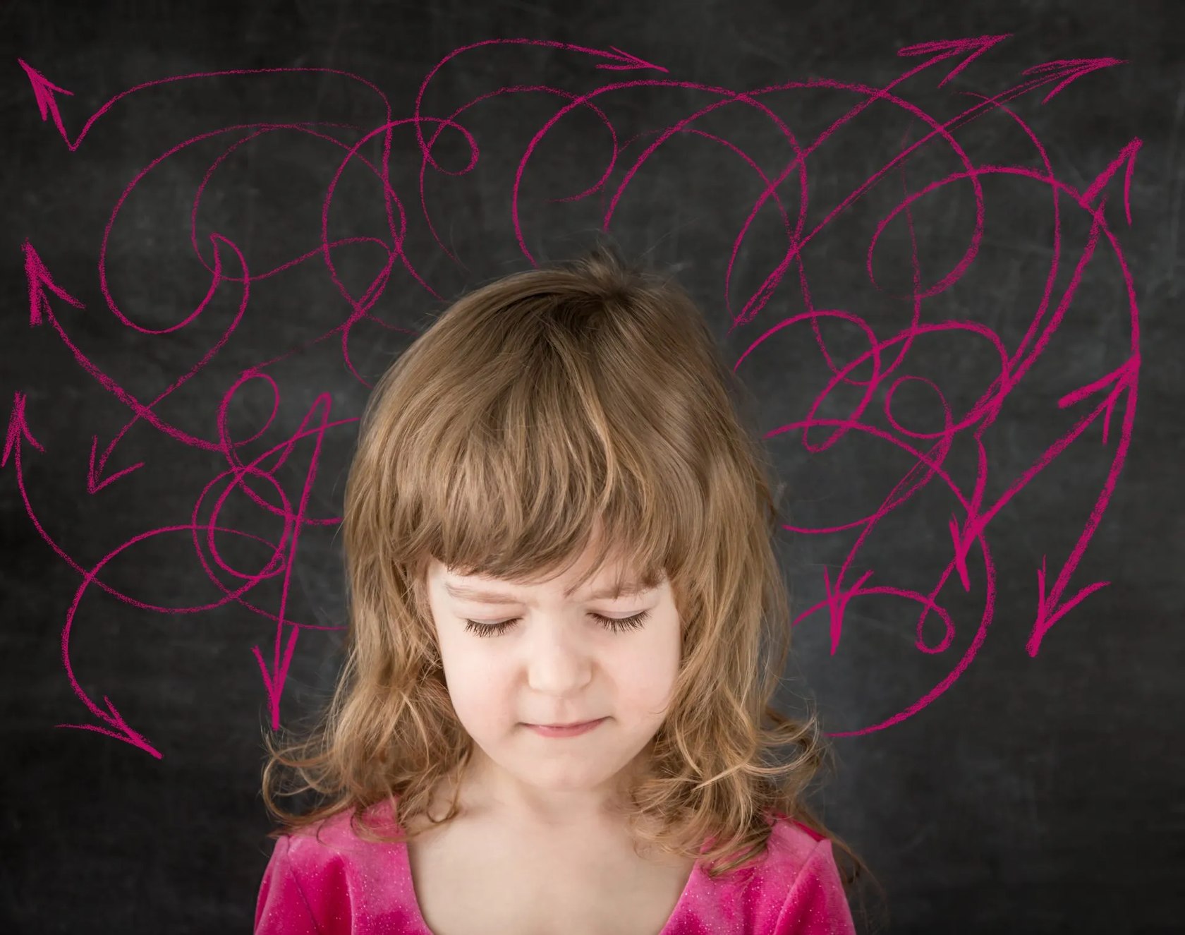 Child with eyes closed in front of chalk-drawn arrows