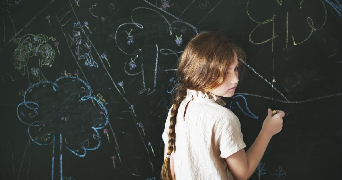 Child drawing with chalk on a blackboard